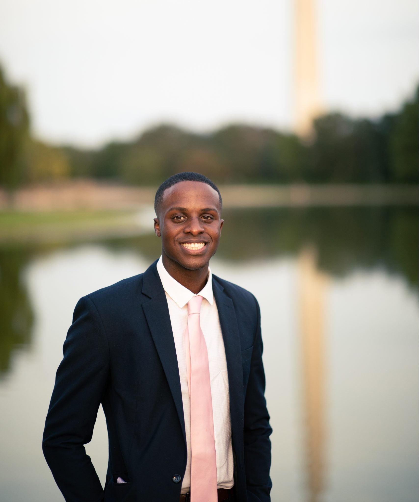 Kevin Russell in a suit, smiling on the National Mall in front of the Washington Monument.
