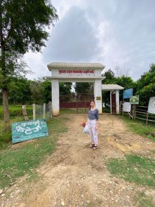 Therese at the entrance to the disappeared persons memorial park in Bardiya