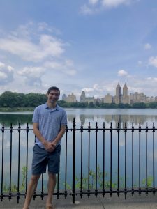 Caleb standing in front of a body of water in Central Park 